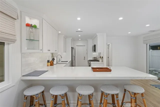 a kitchen with stainless steel appliances a table and chairs in it