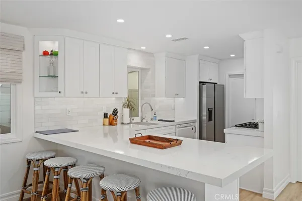 a kitchen with refrigerator and chairs