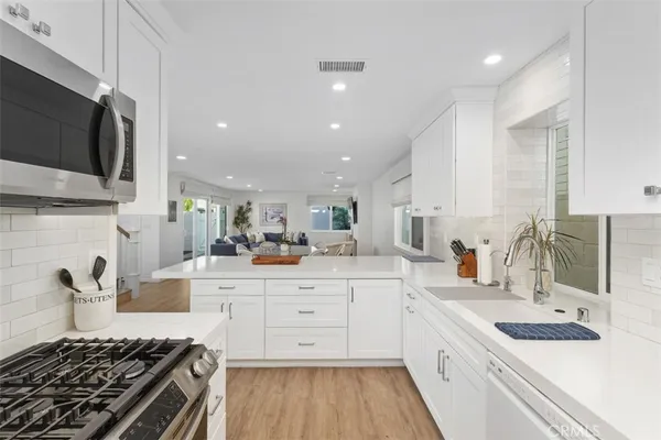 a kitchen with stainless steel appliances kitchen island granite countertop a sink stove and cabinets