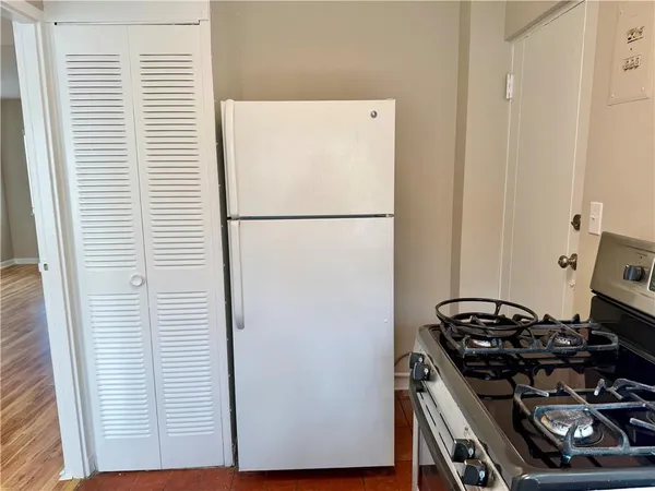 a white refrigerator freezer and a stove sitting inside of a kitchen