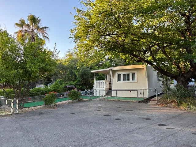 a view of a house with a tree and a yard