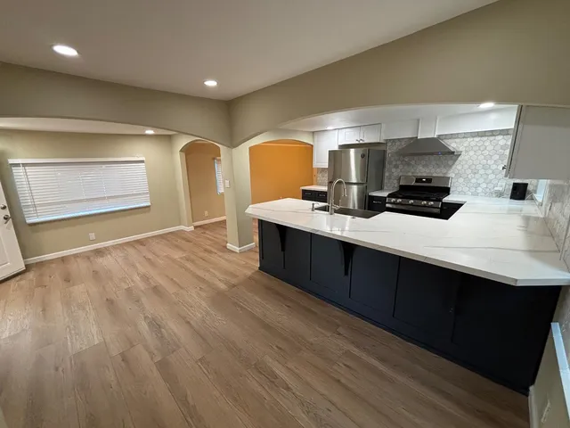a kitchen with a sink a stove and cabinets