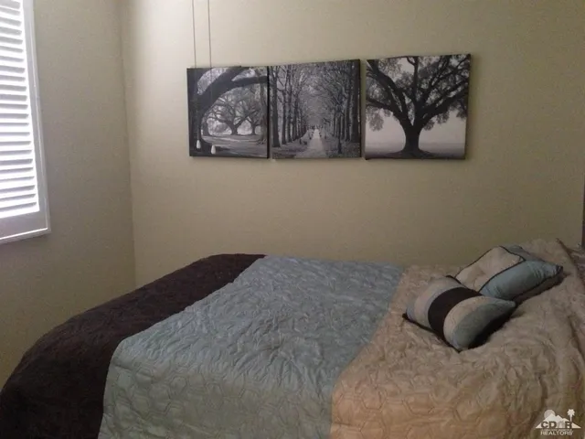 a bedroom with a bed and wall painting