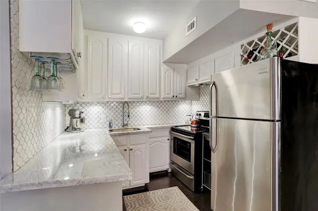 a kitchen with stainless steel appliances granite countertop a refrigerator and a sink