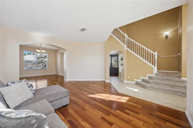 a view of a hallway with wooden floor and a bathroom