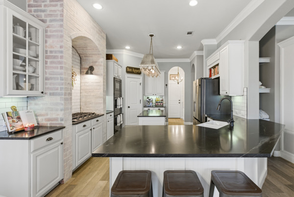 464 Monahans Drive Georgetown, TX 78628 - Photo 13 of 39 a large kitchen with kitchen island granite countertop a sink a counter space and stainless steel appliances