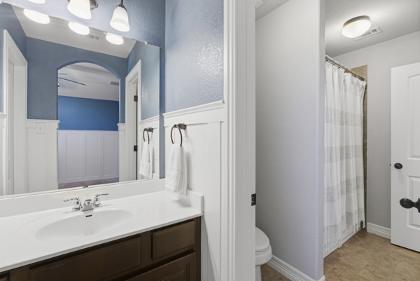 464 Monahans Drive Georgetown, TX 78628 - Photo 26 of 39 a bathroom with a double vanity sink a toilet and a mirror