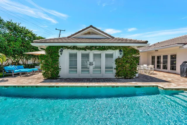 a view of a house with pool backyard a chairs and tables