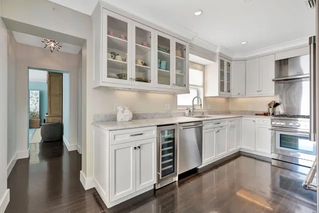 a dining room with furniture a chandelier and large window