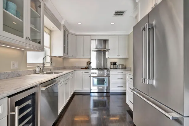 a view of a dining room with furniture a chandelier and kitchen view