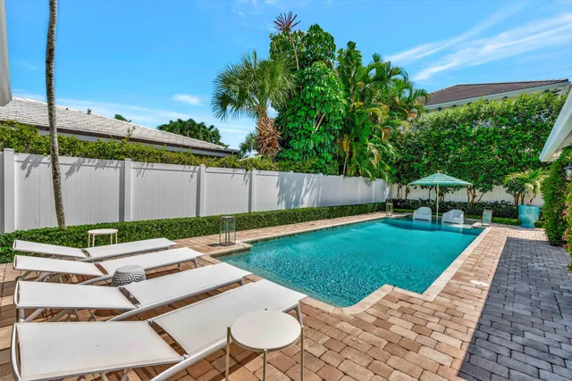 a front view of a house with a yard and potted plants