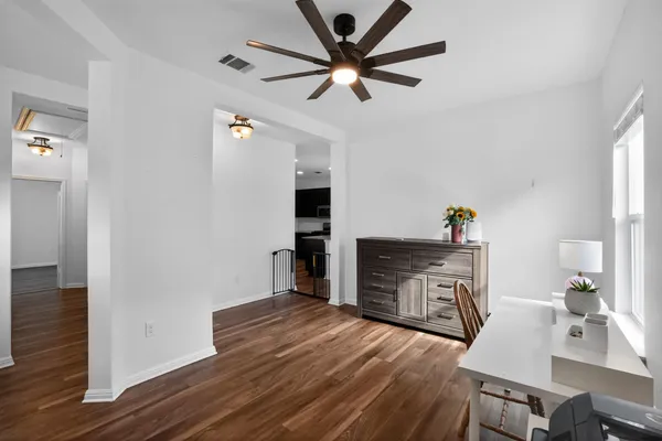 a room with wooden floors and a ceiling fan