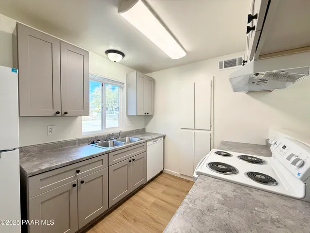 a kitchen with a sink a stove and cabinets