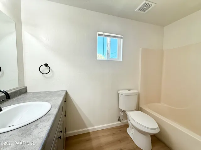 a bathroom with a granite countertop sink mirror vanity and toilet