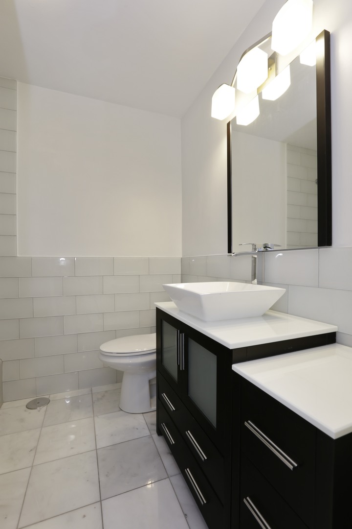5701 North Sheridan Road, Unit 22H Chicago, IL 60660 - Photo 8 of 10 a bathroom with a sink a toilet and a mirror