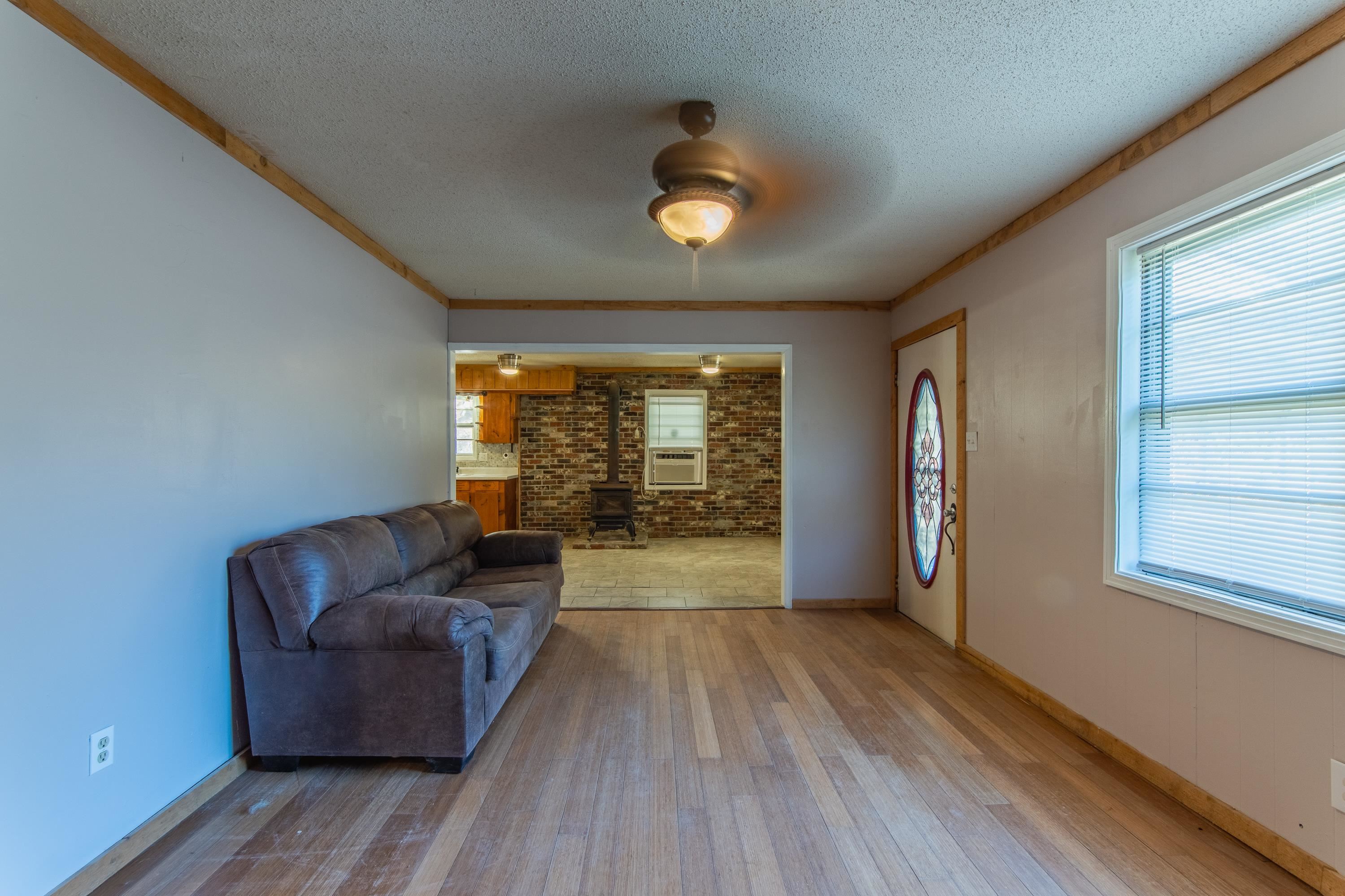 3001 Hamilton Road Ashland, MS 38603 - Photo 12 of 39 Living room featuring a textured ceiling, light hardwood / wood-style floors, a wood stove, and ceiling fan