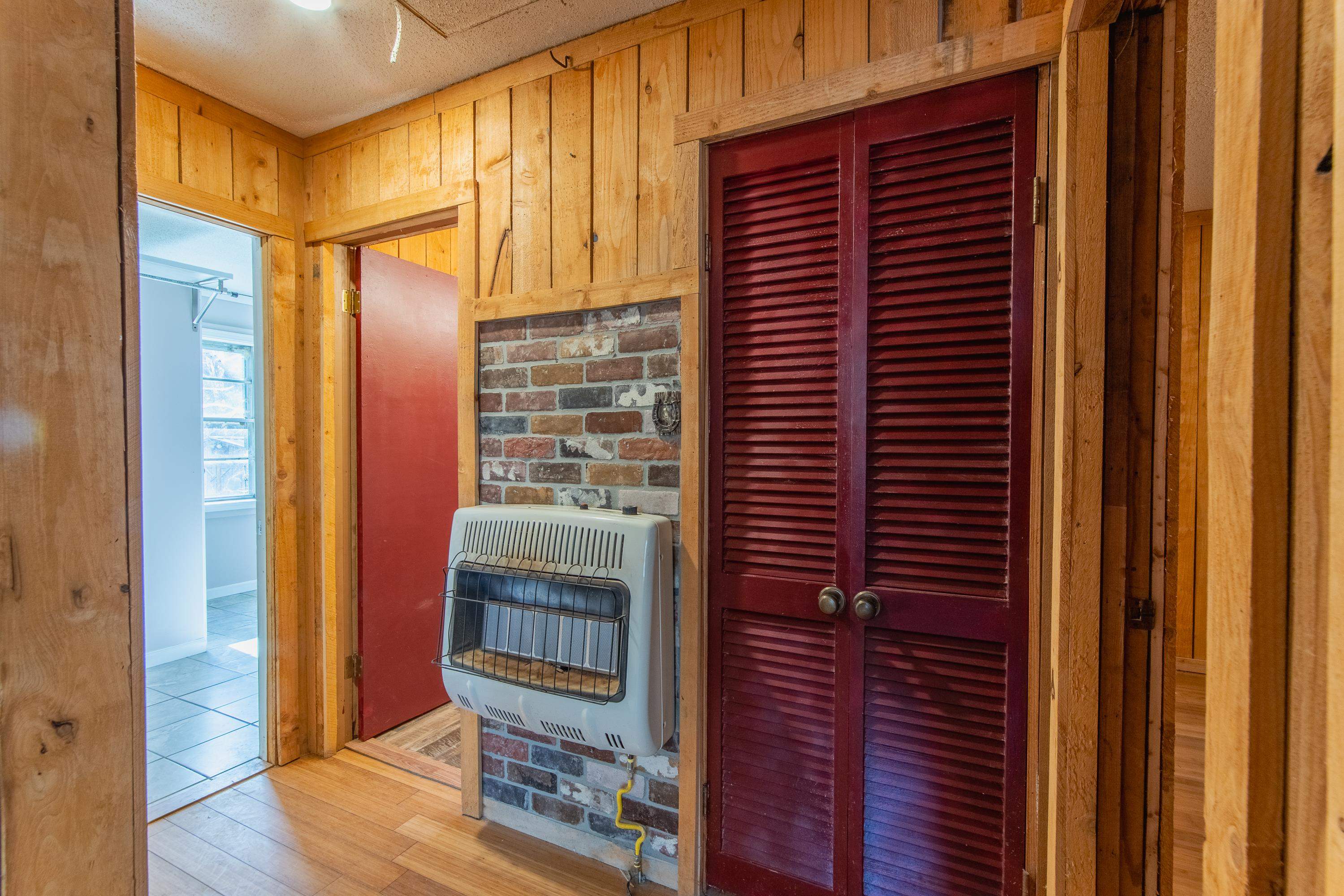 3001 Hamilton Road Ashland, MS 38603 - Photo 14 of 39 Corridor with wood walls, light hardwood / wood-style floors, brick wall, and heating unit