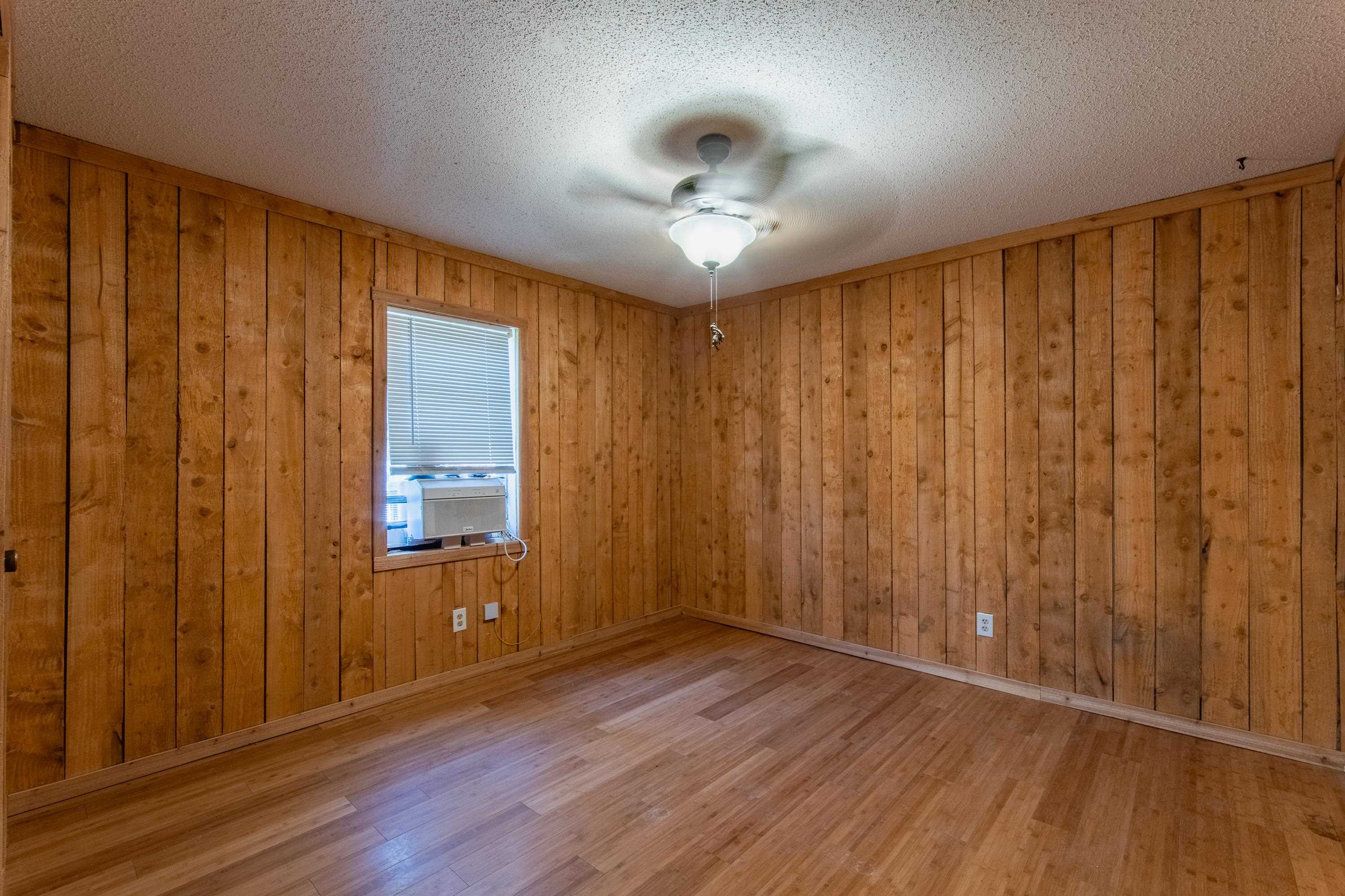 3001 Hamilton Road Ashland, MS 38603 - Photo 9 of 39 Empty room featuring light wood-type flooring, a textured ceiling, ceiling fan, cooling unit, and wood walls