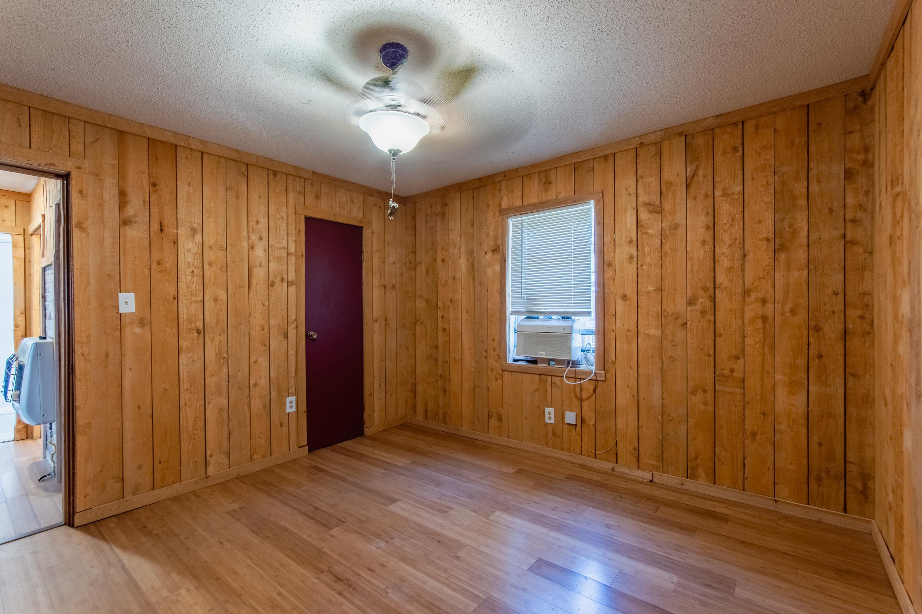 3001 Hamilton Road Ashland, MS 38603 - Photo 10 of 39 Empty room featuring wooden walls, cooling unit, a textured ceiling, and light wood-type flooring
