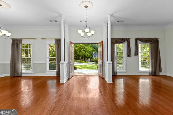 a view of an empty room with wooden floor fireplace and a window