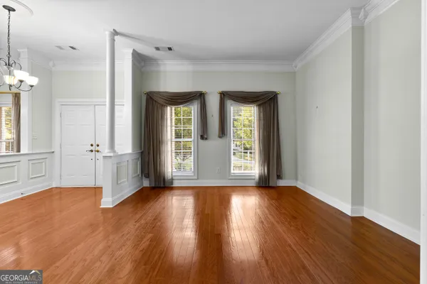 a view of an empty room with wooden floor