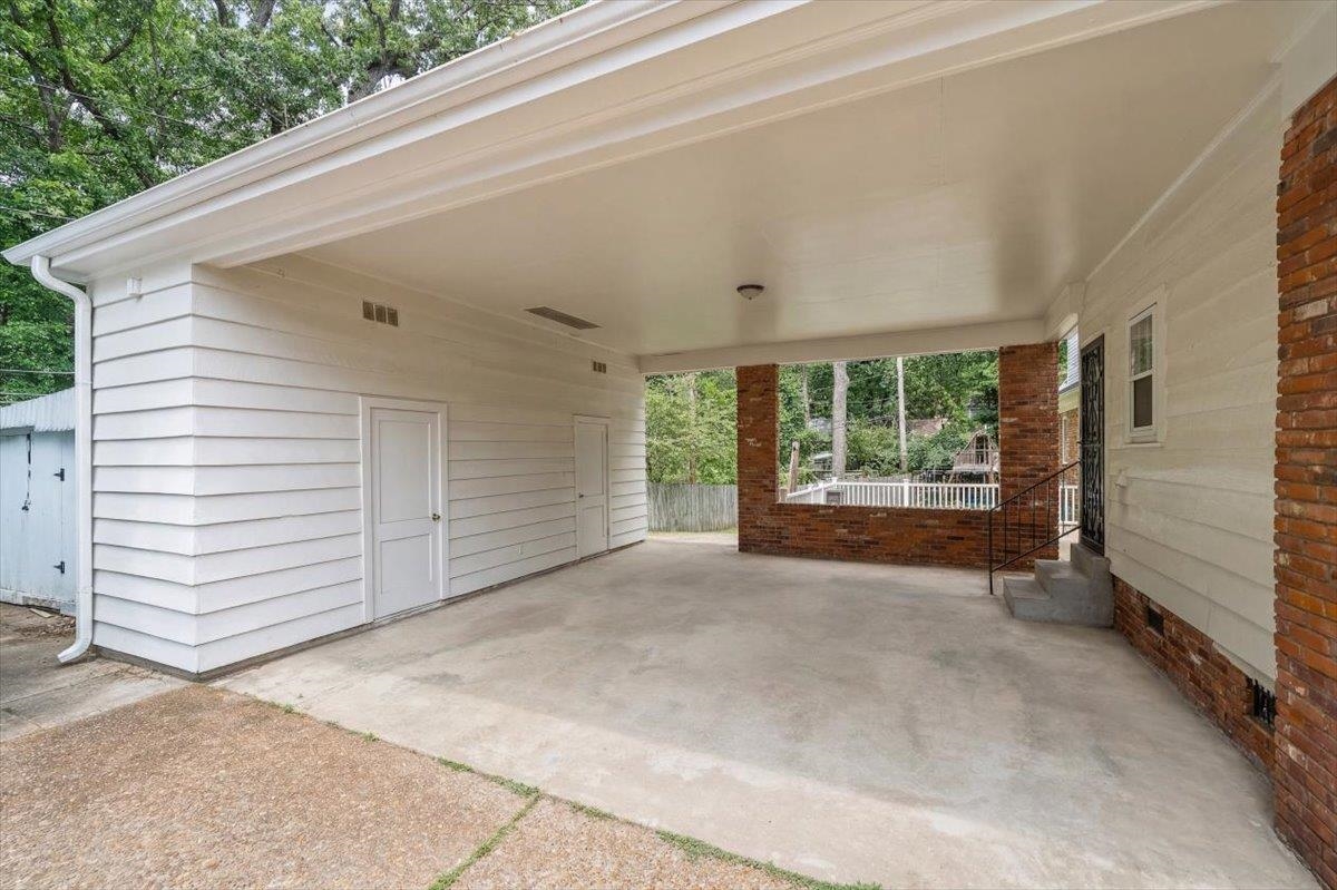 1273 Brookfield Road Memphis, TN 38119 - Photo 32 of 40 Covered carport featuring a concrete floor, white siding, and two storage doors