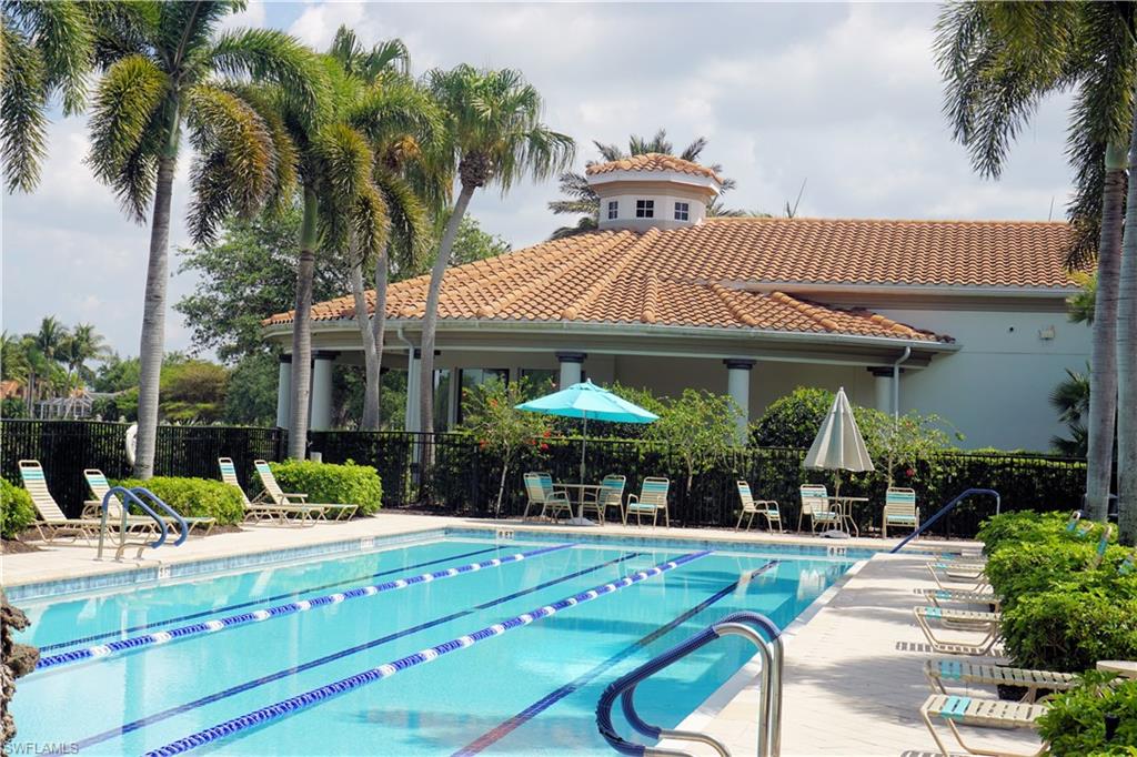 4194 St George Lane Naples, FL 34119 - Photo 19 of 29 a patio with a table and chairs under an umbrella