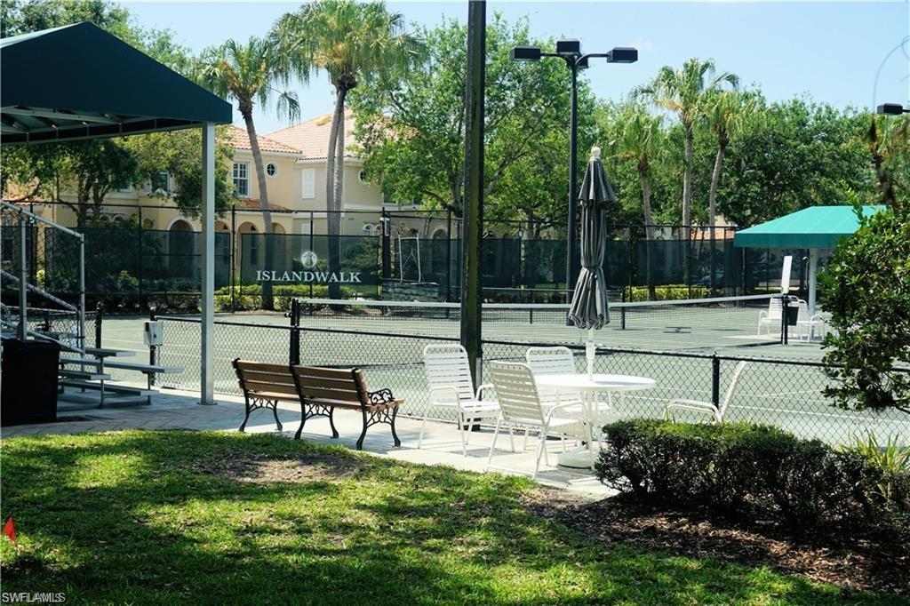 4194 St George Lane Naples, FL 34119 - Photo 20 of 29 a swimming pool with outdoor seating and trees