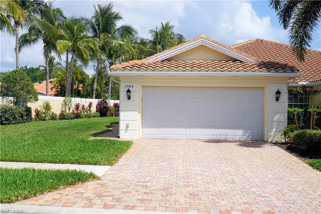 4194 St George Lane Naples, FL 34119 - Photo 2 of 29 a front view of a house with a yard