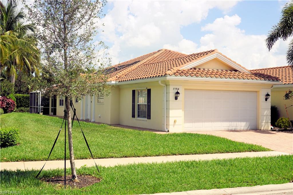 4194 St George Lane Naples, FL 34119 - Photo 3 of 29 a front view of a house with a yard and trees