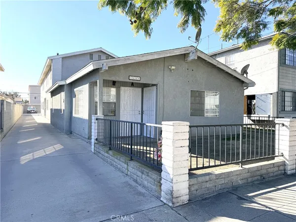 a view of a house with a small yard and wooden fence