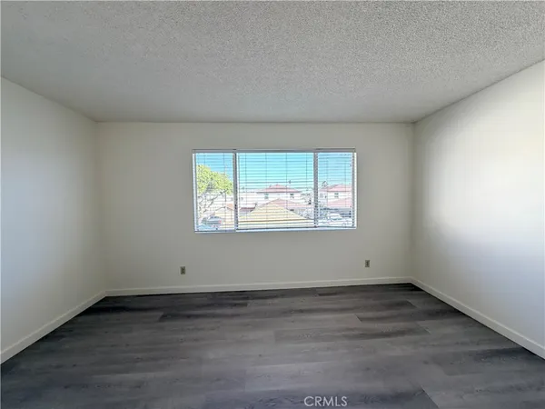 an empty room with wooden floor and window