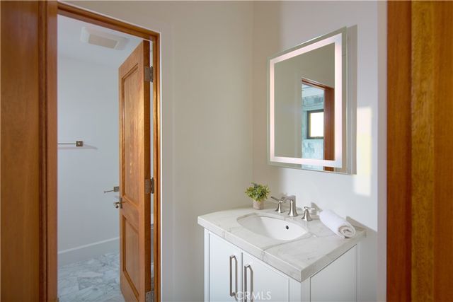 a bathroom with a granite countertop sink a toilet and shower