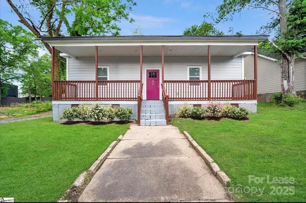 a front view of a house with a yard and garden