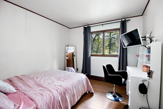 a bedroom with a bed and a flat screen tv