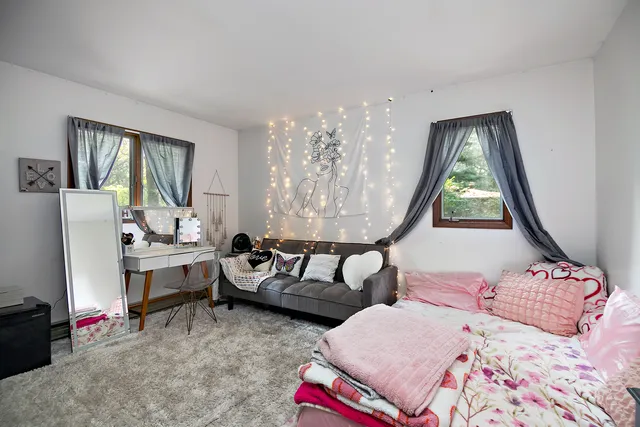 a bedroom with furniture and a large window