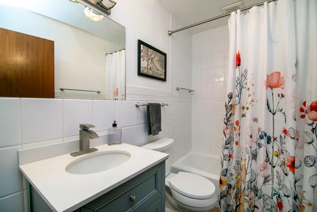 a bathroom with a sink vanity mirror and toilet