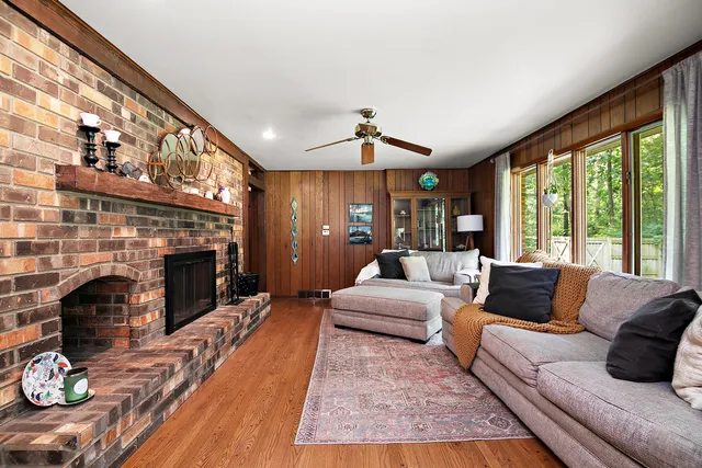 a living room with furniture large window and a fireplace