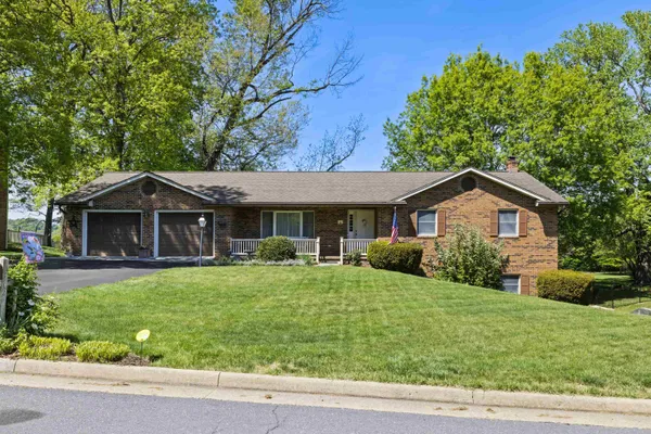 a front view of a house with yard and green space