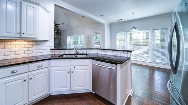 a kitchen with granite countertop a sink and cabinets