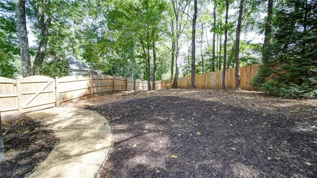 a view of backyard with green space and trees