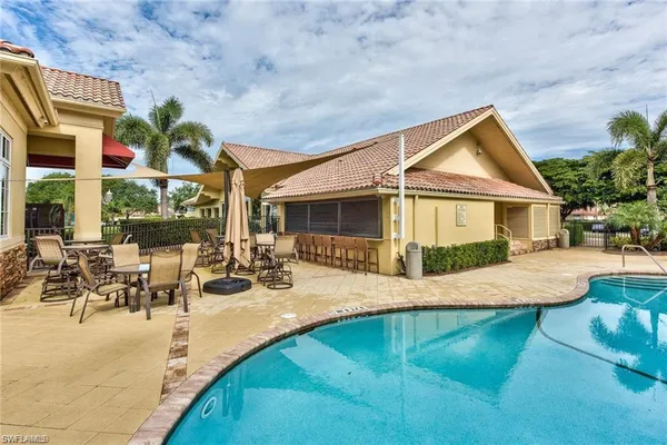 a view of a house with pool and sitting area