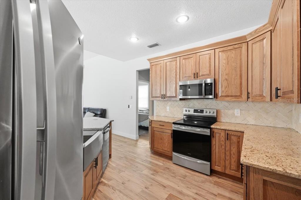 2214 Longmore Circle Valrico, FL 33596 - Photo 23 of 61 a kitchen with stainless steel appliances granite countertop a stove a sink and a refrigerator