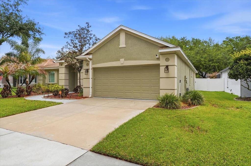 2214 Longmore Circle Valrico, FL 33596 - Photo 58 of 61 a front view of a house with a yard and garage