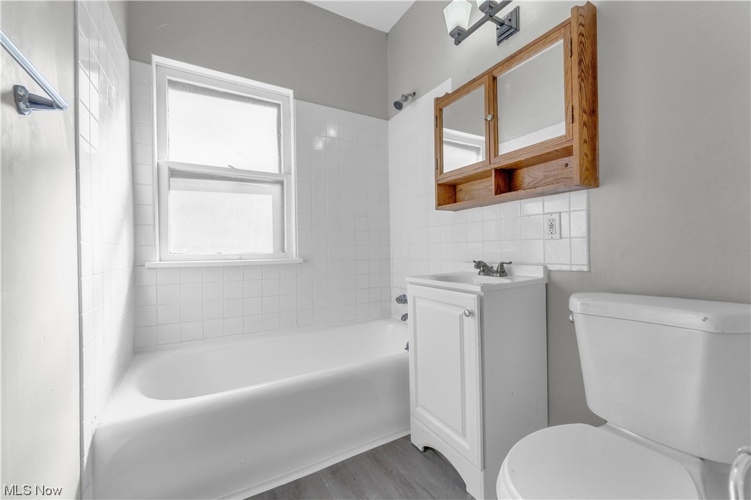 1499 Sherbrook Road South Euclid, OH 44121 - Photo 21 of 41 Full bathroom featuring toilet, hardwood flooring, vanity with extensive cabinet space, and tiled shower / bath combo