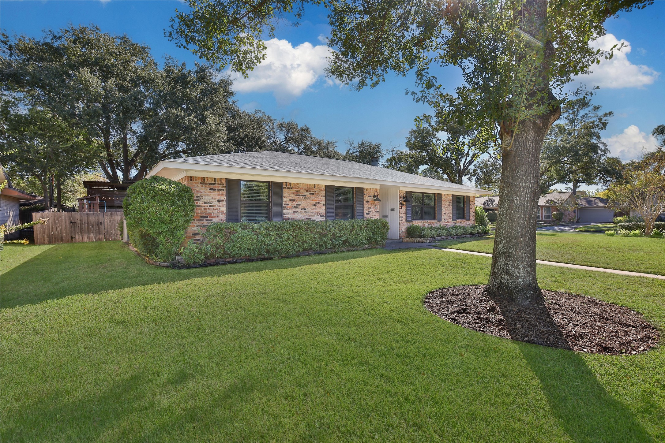 Inviting front exterior with manicured landscaping and a spacious lawn