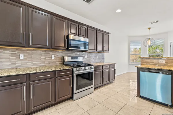 a kitchen with stainless steel appliances granite countertop a stove microwave and sink