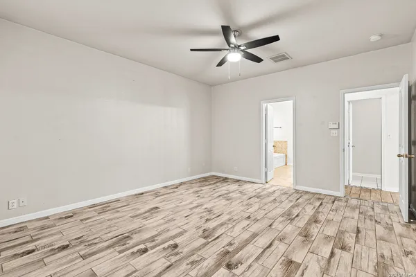 a view of empty room with wooden floor