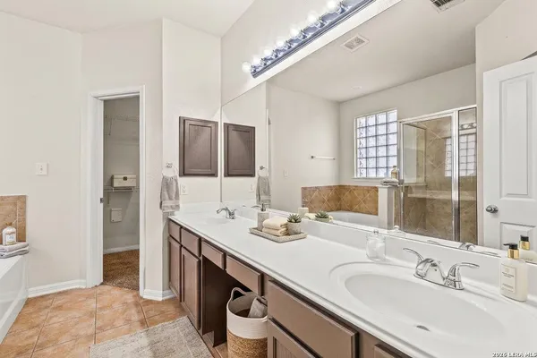 a bathroom with double vanity sinks and a mirror