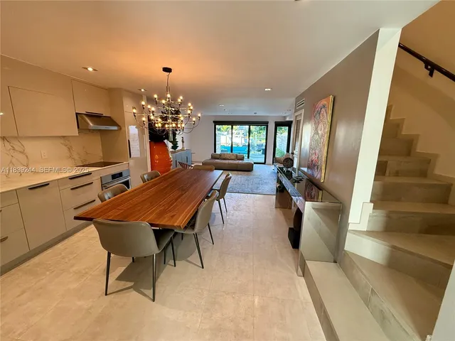 a dining room with furniture a chandelier and wooden floor